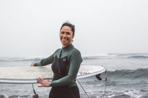 Nathalie Van Renterghem holding a surfboard